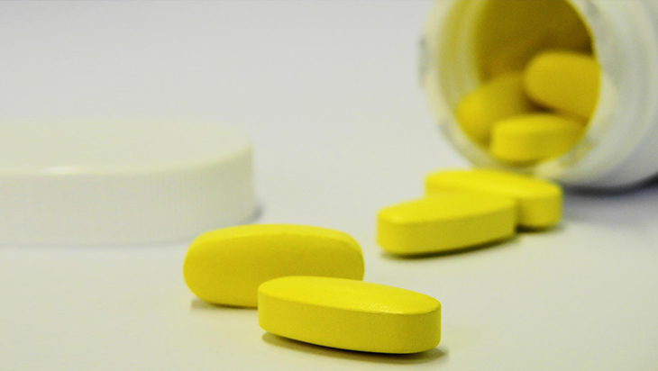 Close up of yellow prescribed pills spilt over