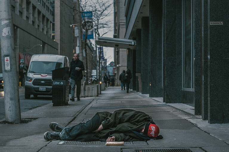 a person laying on the sidewalk in front of a building