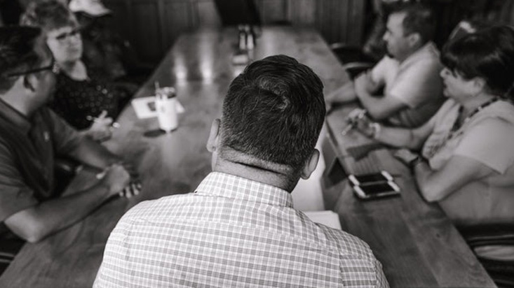 Grayscale photo of people in a meeting 