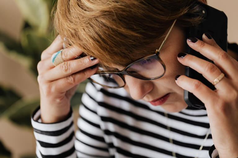Woman calling a toll-free hotline for addiction support