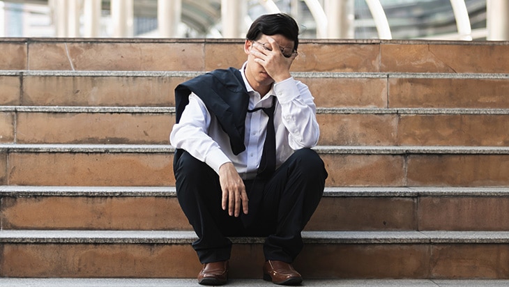 A man stressed outside his place of work