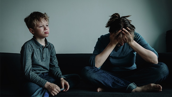 Mother and son crying on a couch