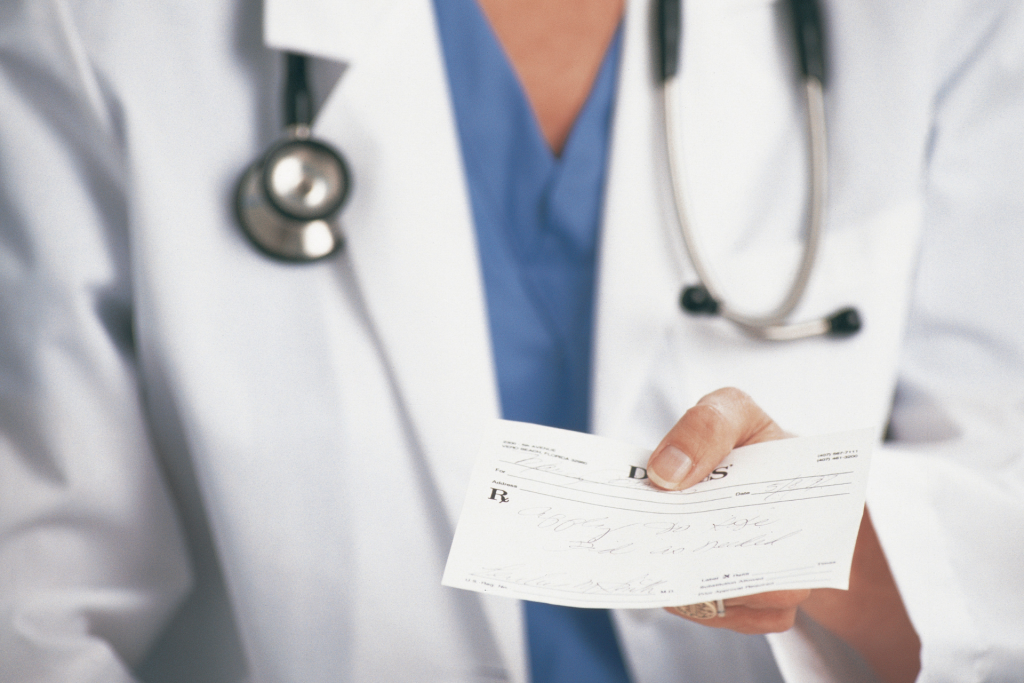 Closeup of a doctor holding a prescription slip