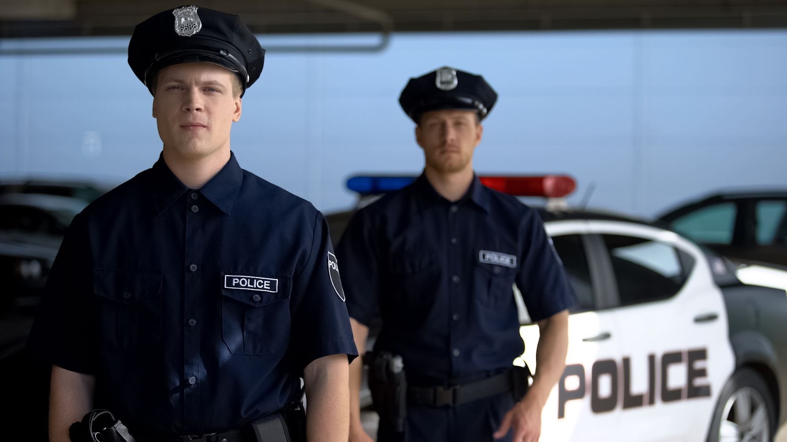 Police officers standing in front of a police car