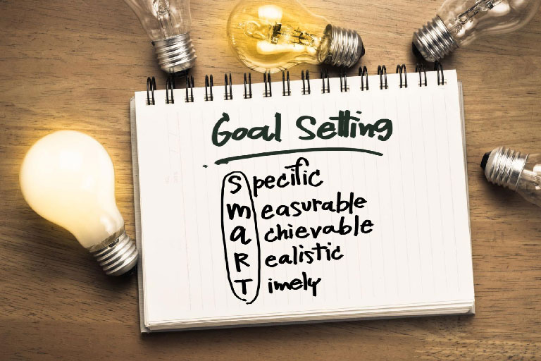 A notebook with a SMART goal setting written on it 