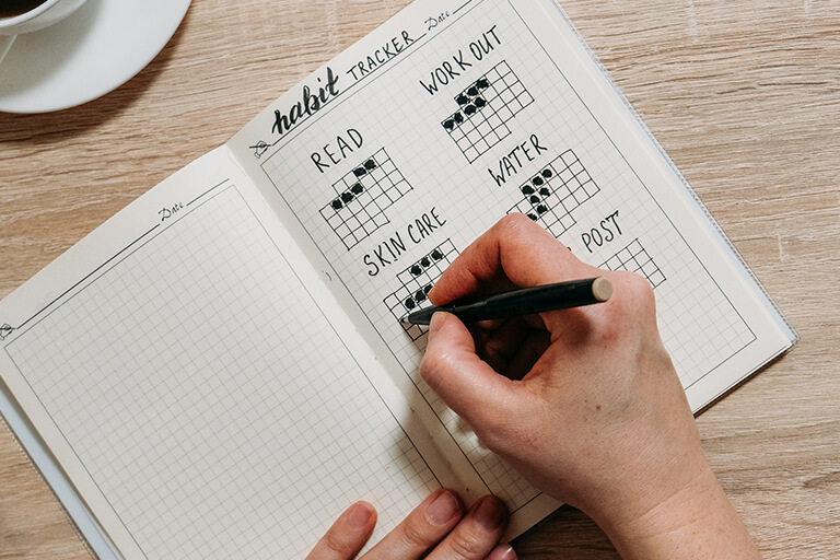 A person keeping track of their habits in a bullet journal