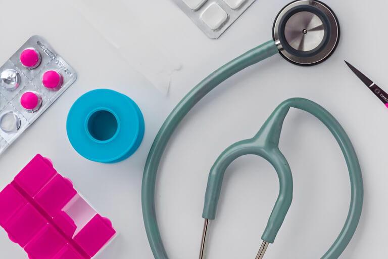 A green stethoscope and different kinds of drugs on the table.
