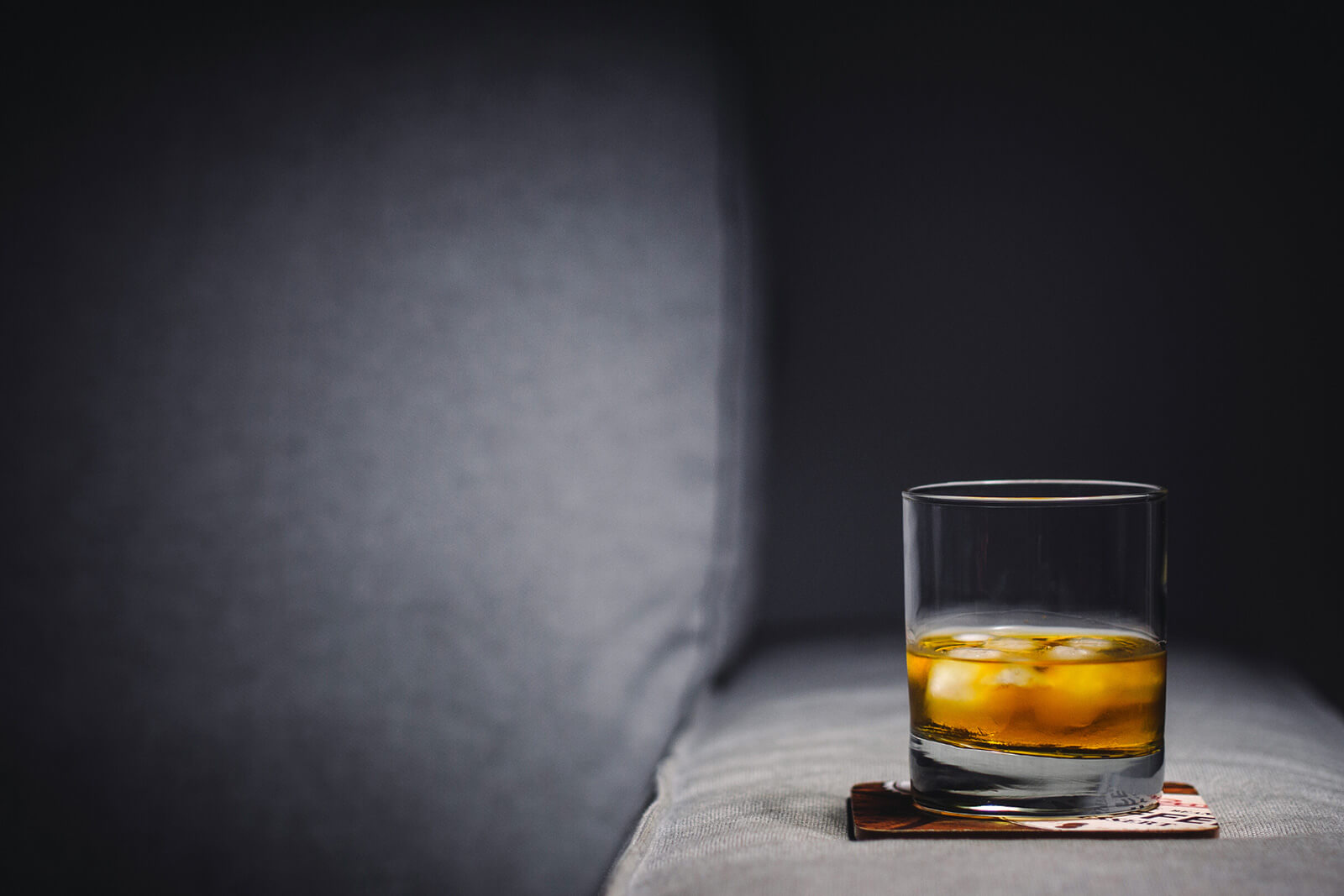 A glass of alcohol sitting on a coaster