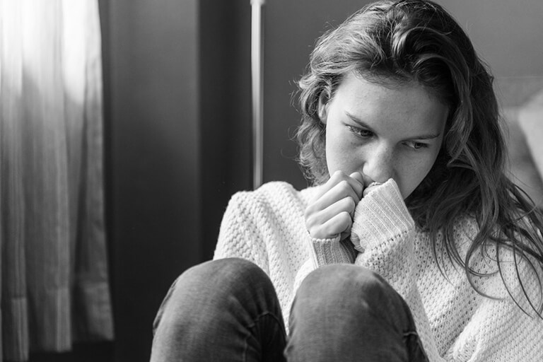 Drug addict in codependent relationship crying in a room
