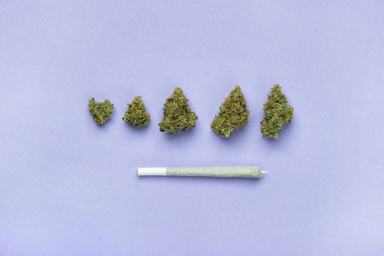 A range of weed bud sizes and a rolled joint
