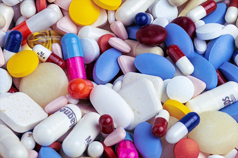 A close-up of different pills and tablets of various colours and shapes