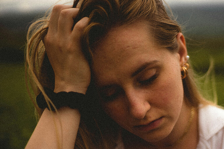 A woman with her head in her hand looking upset