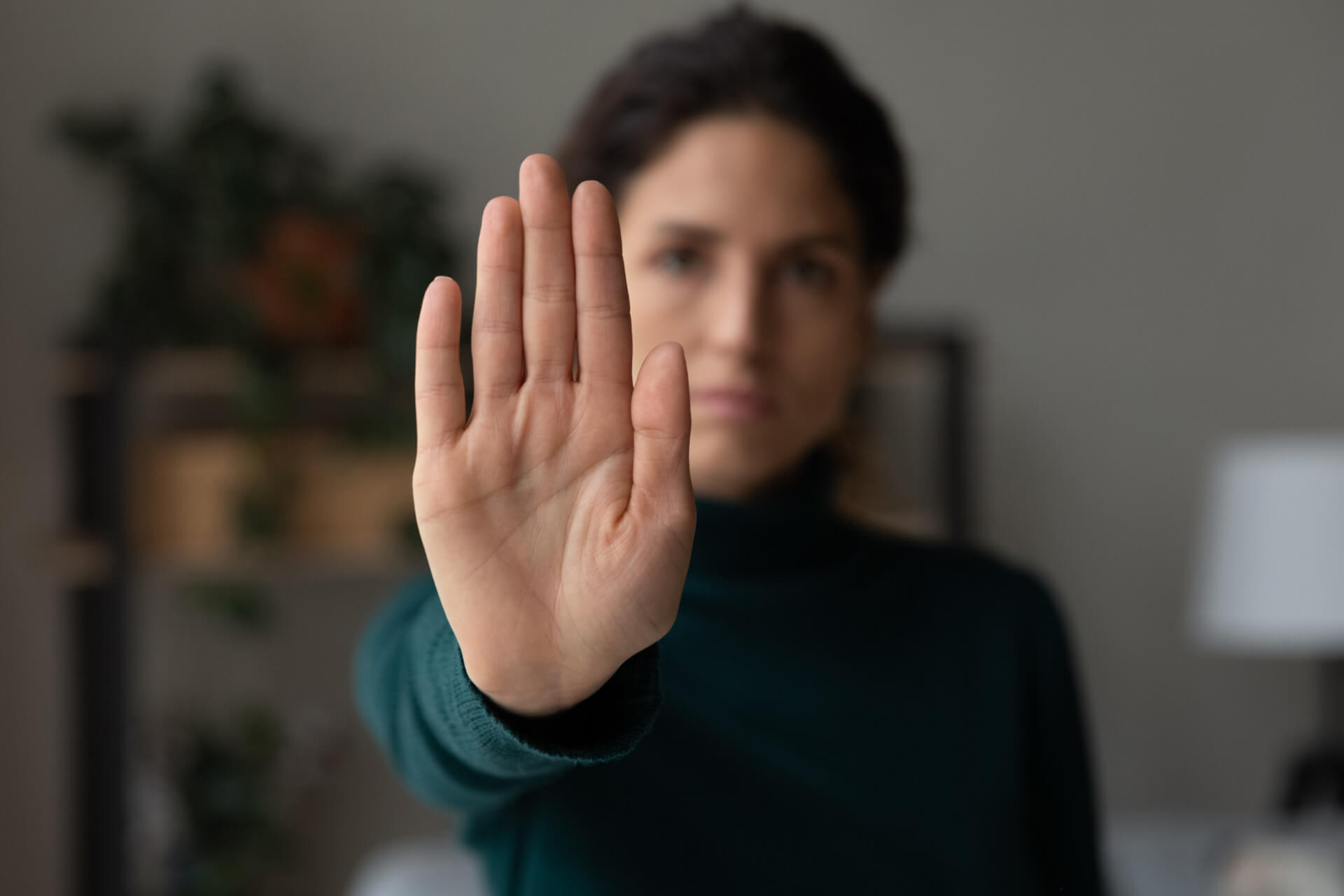 woman holds her hand up to say no to alcohol
