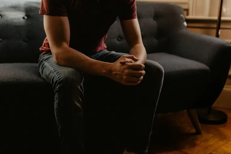 A man sitting on a couch discussing how he is feeling
