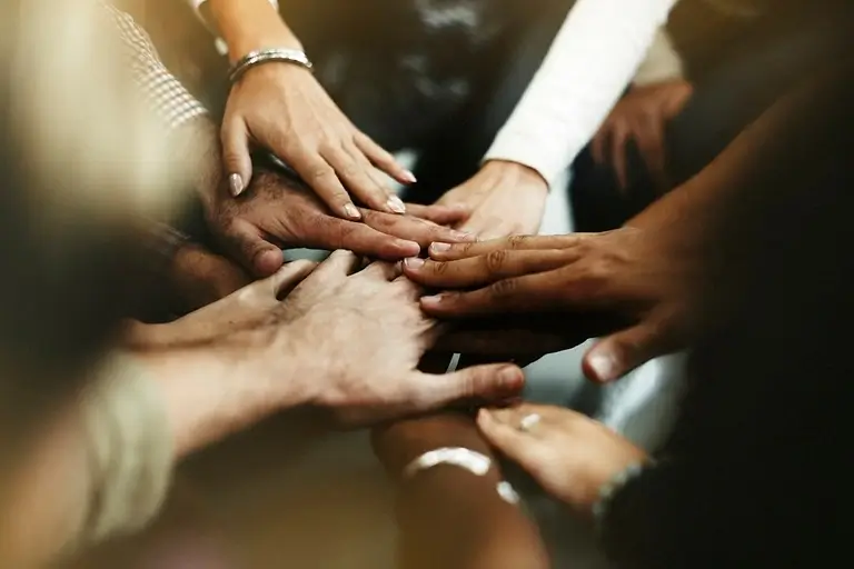 A circle of hands reaching out in support