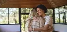 A treatment advocate smiles as she embraces the individual she is supporting.
