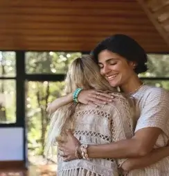 A treatment advocate smiles as she embraces the individual she is supporting.