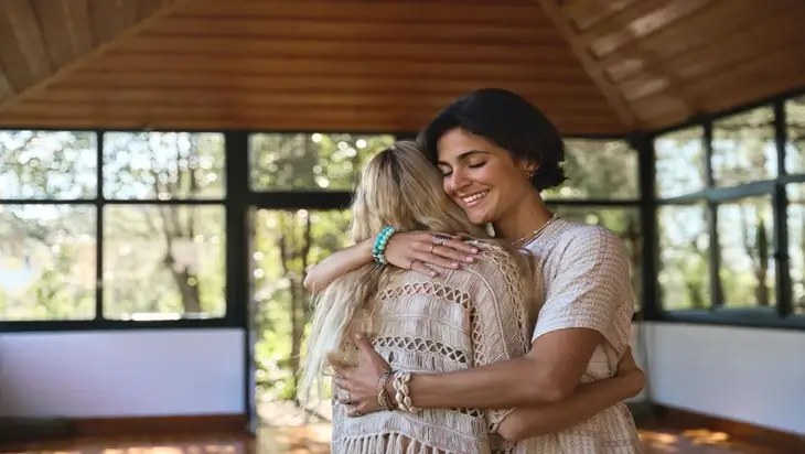 A treatment advocate smiles as she embraces the individual she is supporting.