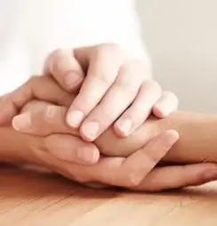A close-up of two hands gently clasped together.