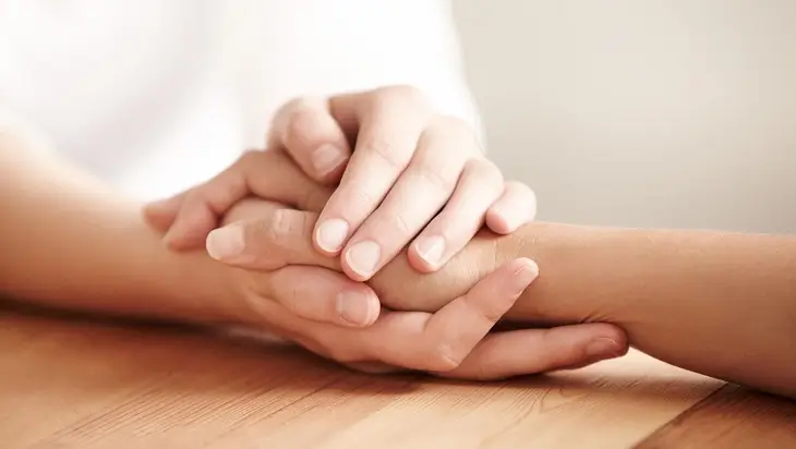 A close-up of two hands gently clasped together.